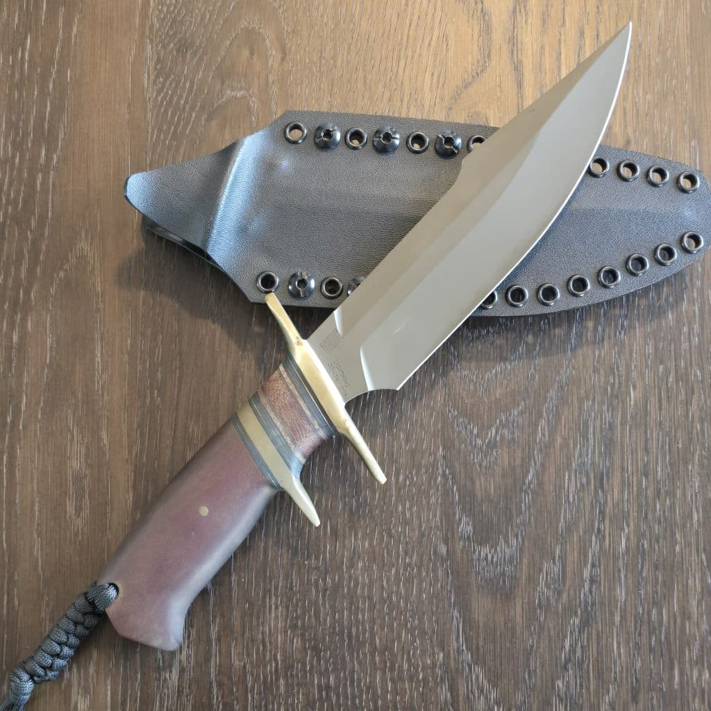 Behring Technical "Lightning" in O1 tool steel with green Cerakote finish Brass hilts with natural micarta, brass, and black spacers Paper micarta handle Thong hole with braided lanyard Kydex sheath with Tek-Lok style clip Marked 03-14, 016
