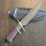 Behring Technical "Lightning" in O1 tool steel with green Cerakote finish Brass hilts with natural micarta, brass, and black spacers Paper micarta handle Thong hole with braided lanyard Kydex sheath with Tek-Lok style clip Marked 03-14, 016